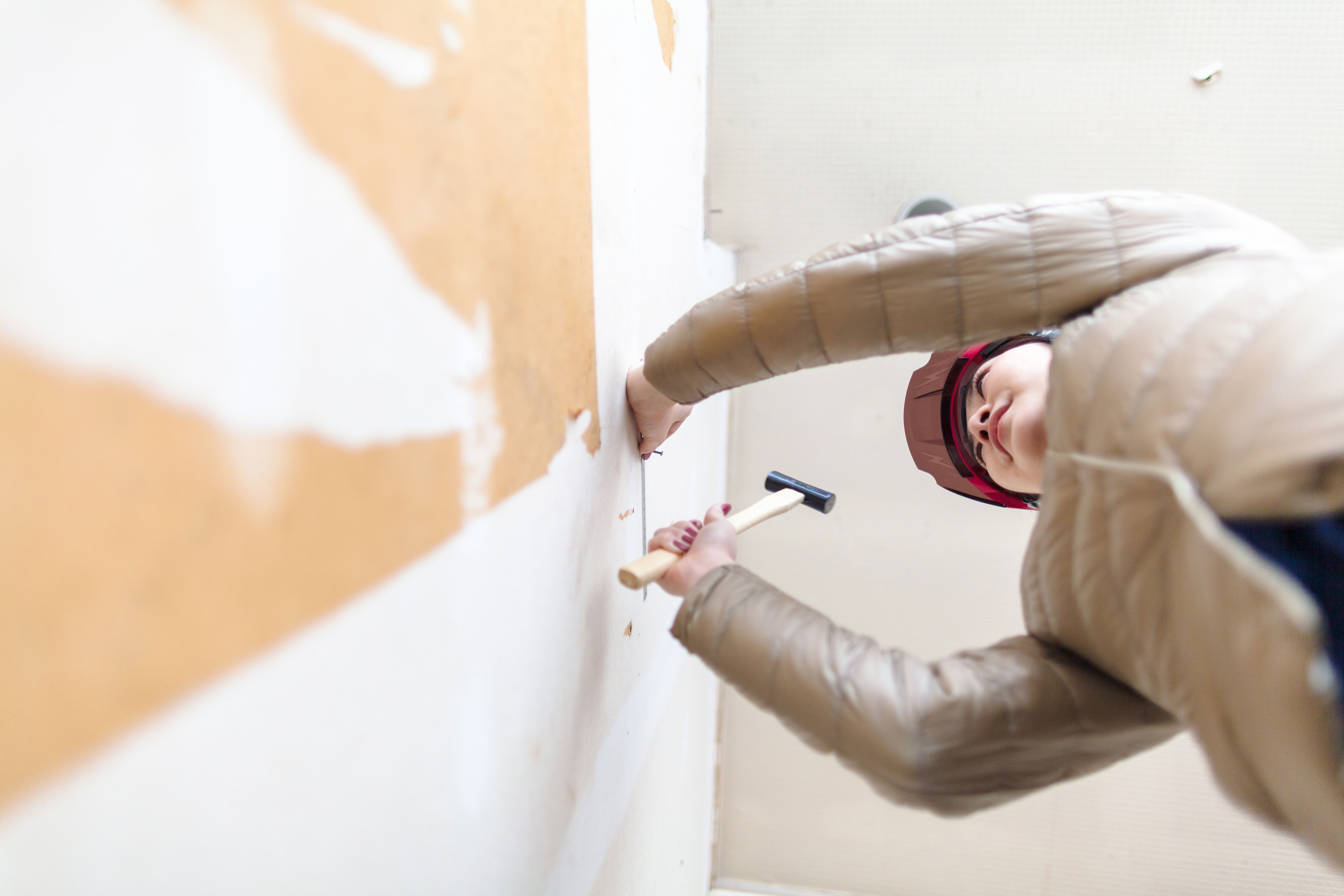 Hands hanging a framed picture on a wall, symbolizing home